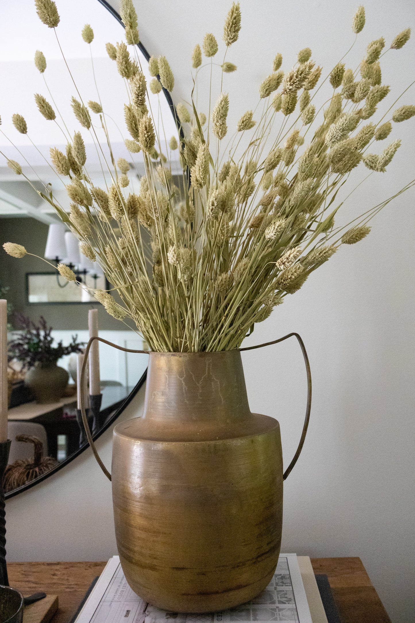 Bronze vase with dried plants on a table
