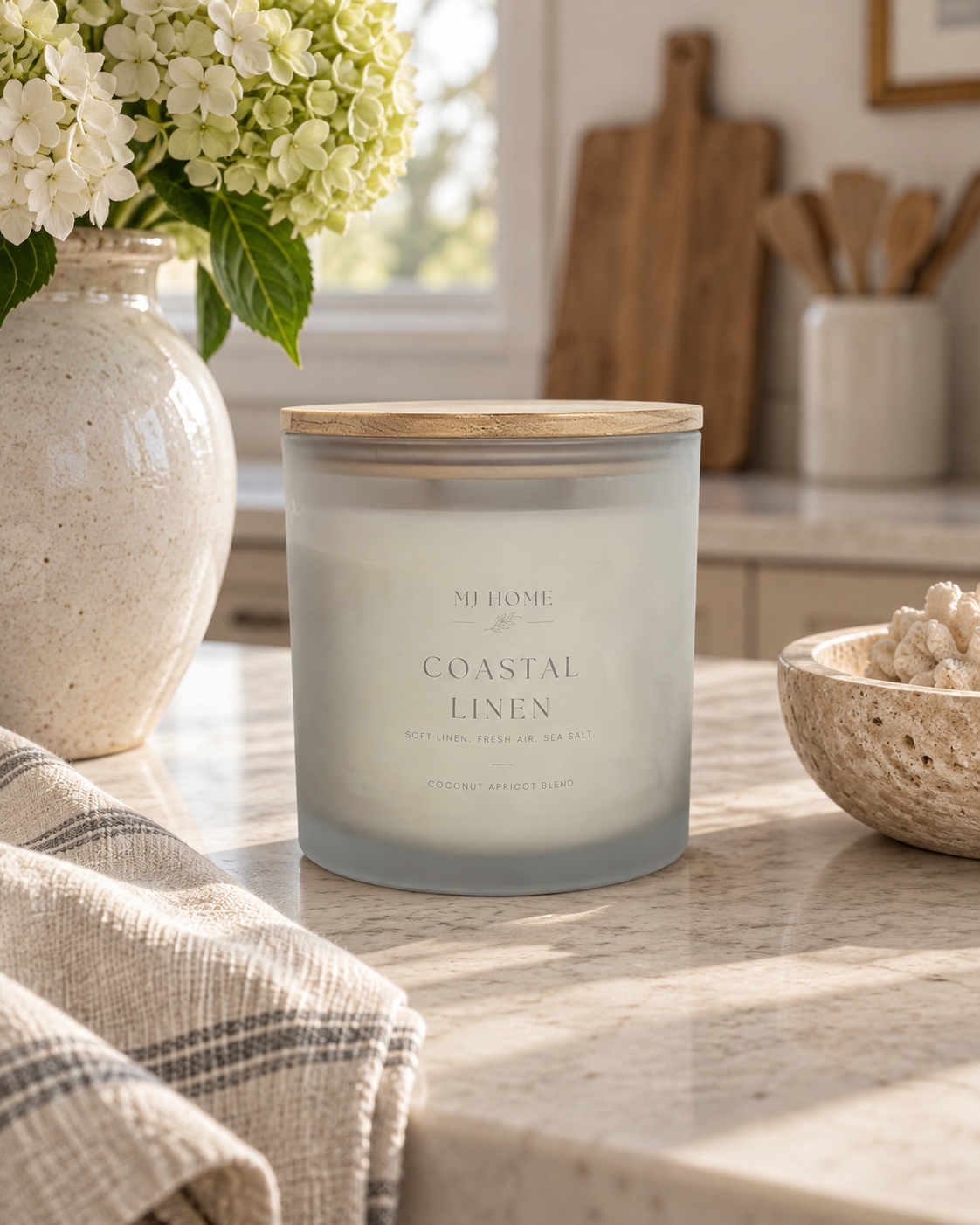 MJHome Estate 4-wick Coastal Linen scented candle in a large frosted glass vessel with natural bamboo lid and black MJHome gift box