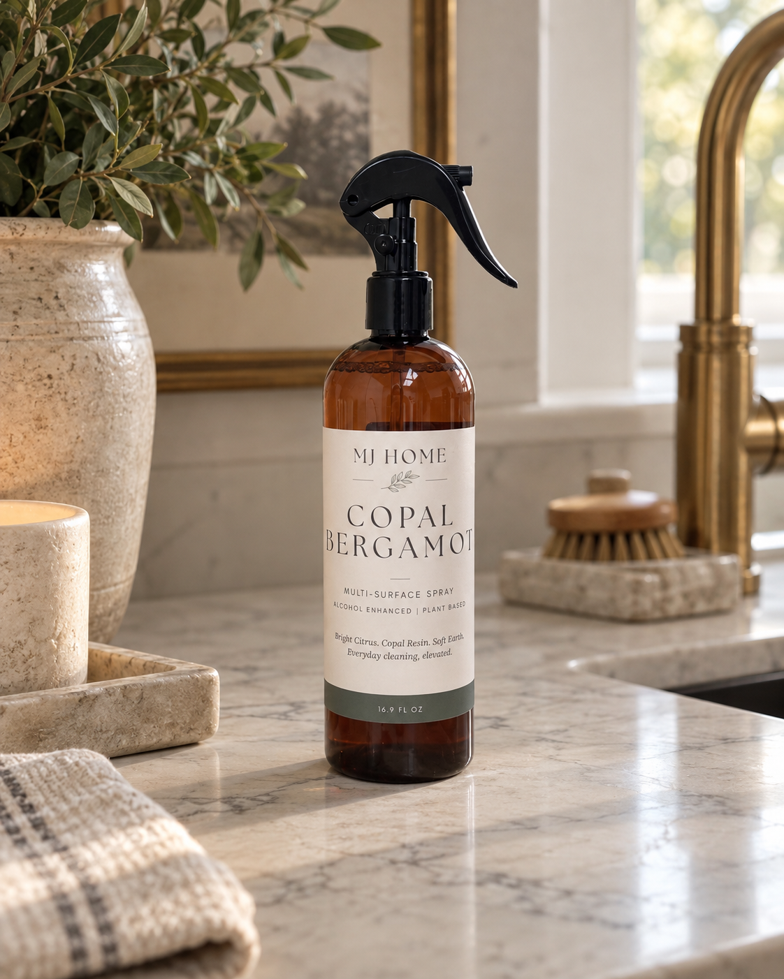 MJHome Copal Bergamot multi-surface cleaning spray in an amber bottle with black trigger sprayer on a kitchen countertop