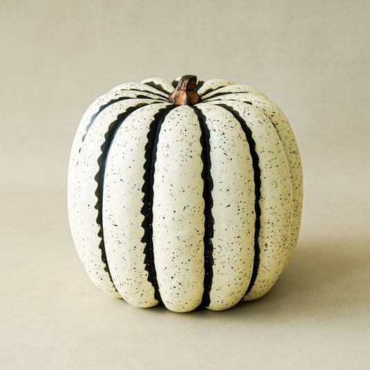 White pumpkin with black stripes on a beige background