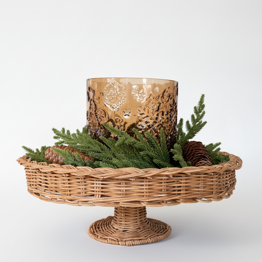 Decorative basket with a candle and greenery on a white background