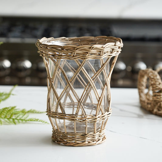 Wicker candle holder with glass insert on a white surface