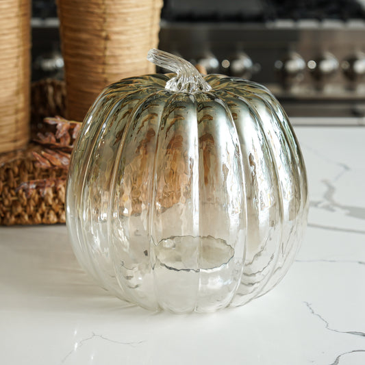 Glass pumpkin on a marble surface with a blurred background