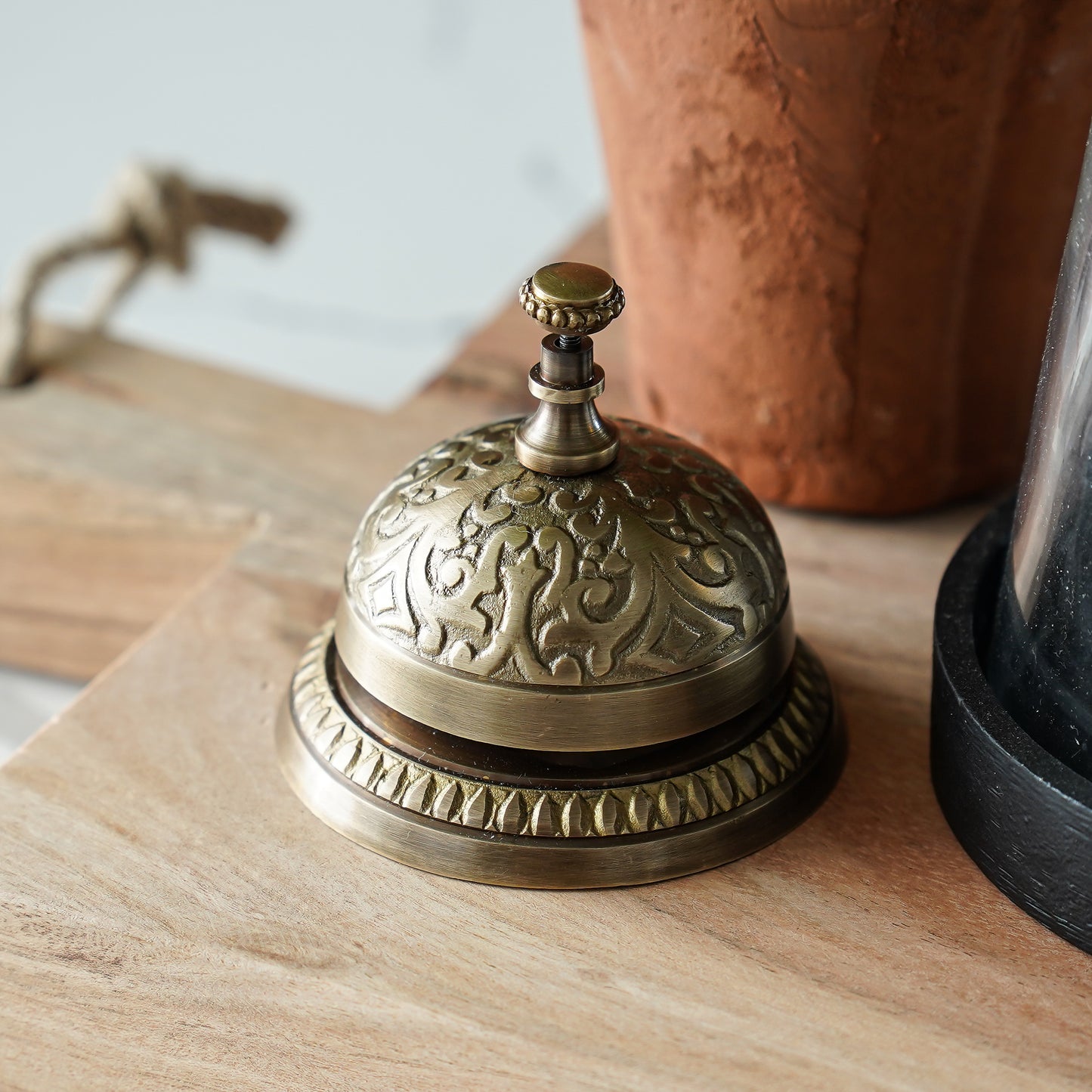 Decorative brass bell on a wooden surface with a blurred background