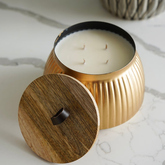 Gold candle holder with wooden lid on a marble surface