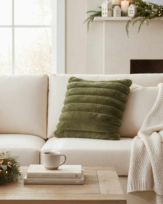 Cozy living room with a white sofa, green pillow, and Christmas decorations.