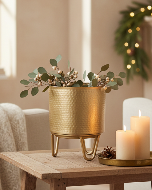 Cozy living room with a small table holding a candle and plant, near a fireplace with Christmas decorations.