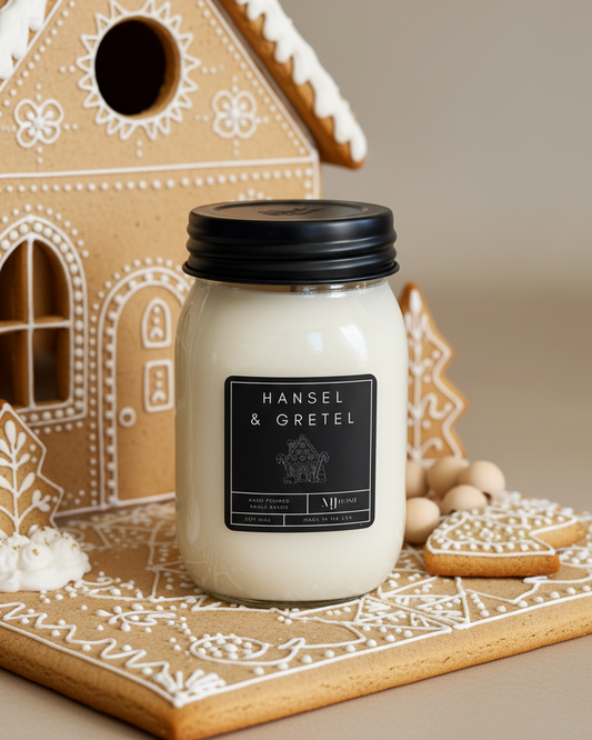Candle with a 'Hansel & Gretel' label in front of a gingerbread house decoration.