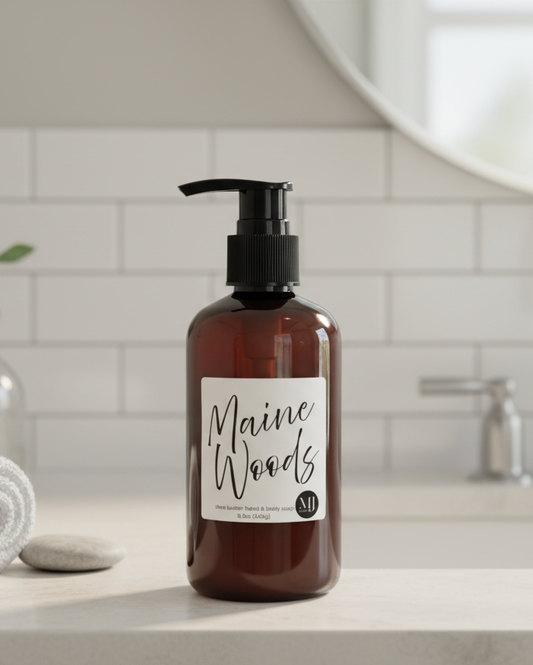 Brown bottle with pump and 'Maine Woods' label on a bathroom counter.