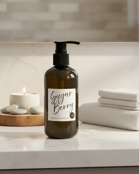 Bottle of soap labeled 'Ginger Berry' on a bathroom counter with towels and decor.