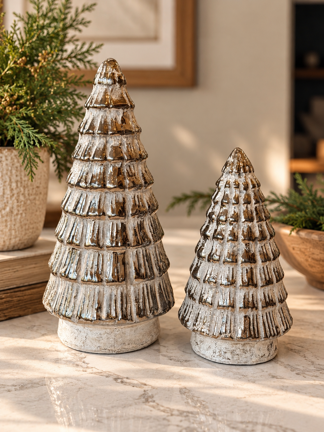 Two antique terracotta Christmas trees with layered branches, distressed brown finish and whitewashed detailing in coordinating sizes