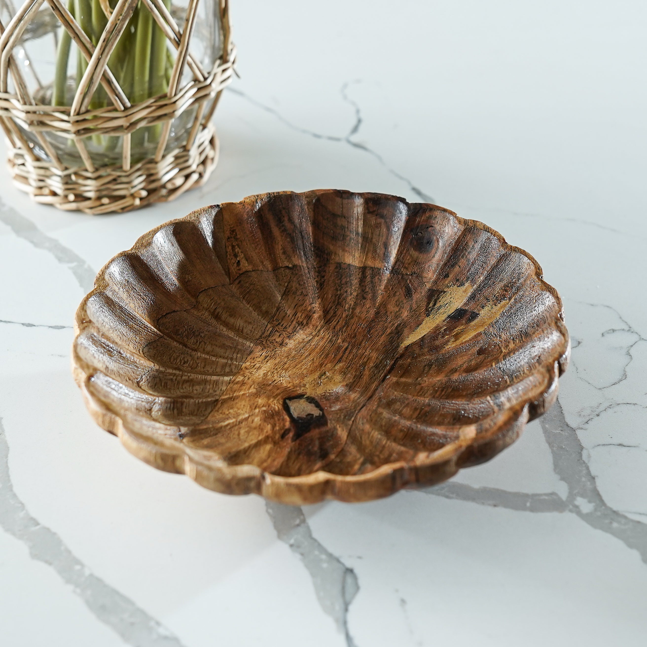 Wooden bowl on a marble surface with a woven basket in the background