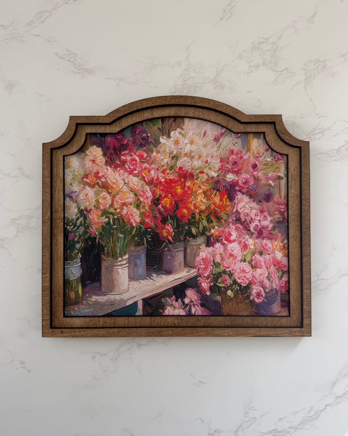 Framed artwork of flowers on a marble wall