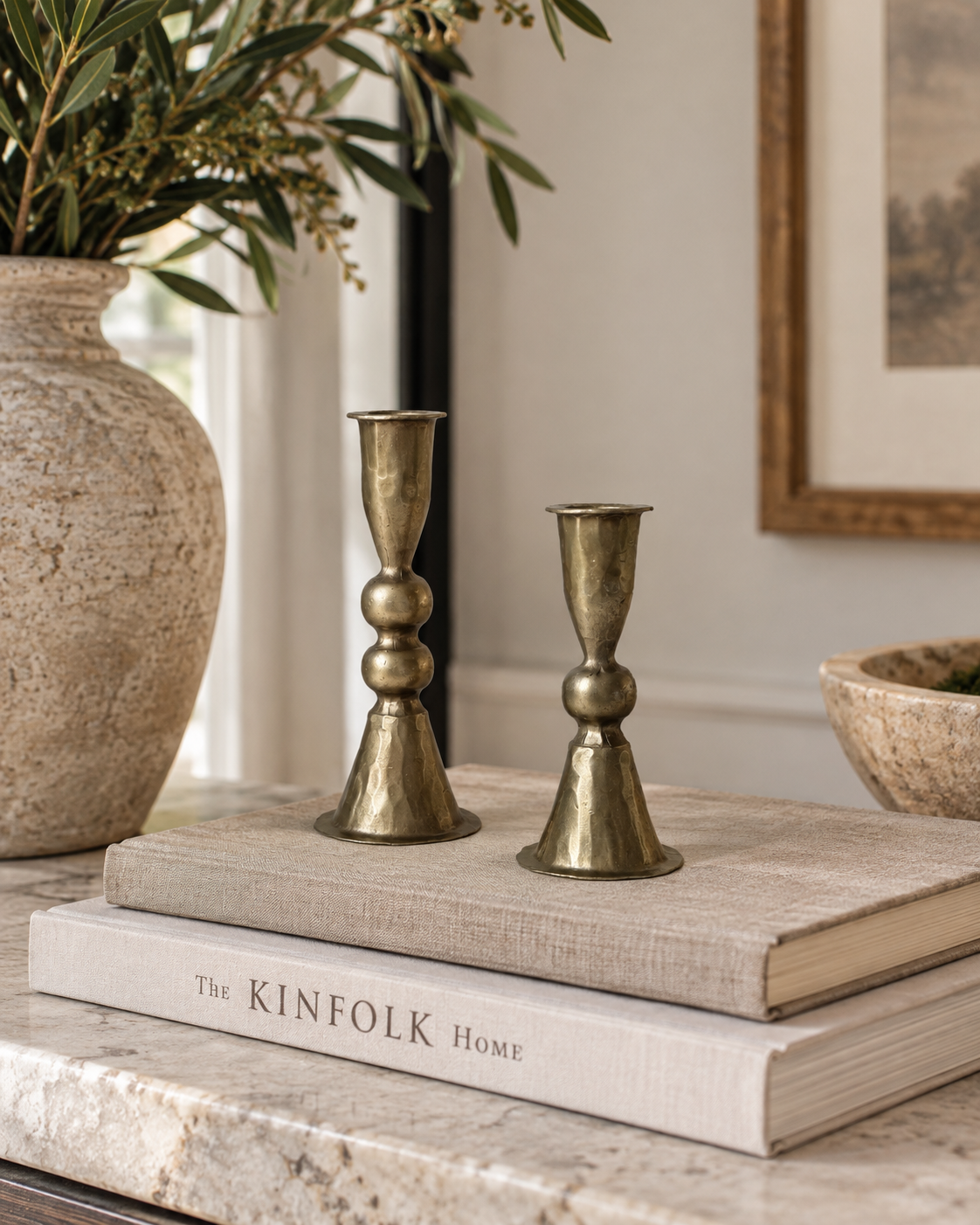Set of two antique brass taper candle holders with decorative stacked-ball details, pedestal bases and graduated heights