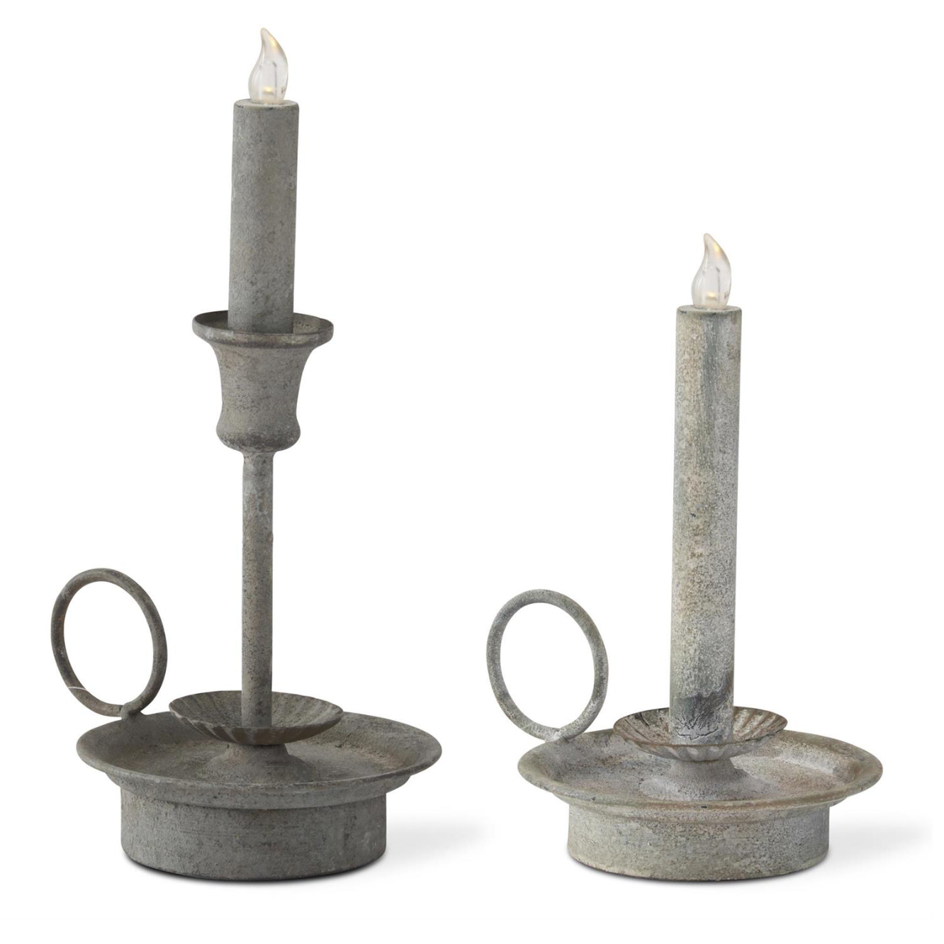 Two metallic candle holders with lit candles on a white background