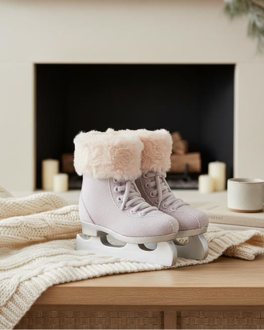 Pink roller skates with white fur trim on a wooden surface in front of a fireplace.
