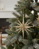 Decorated Christmas tree with star-shaped ornament in a living room setting.