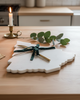 Decorative cutting board with greenery on a kitchen counter
