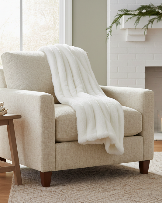 Beige armchair with a white blanket in a cozy living room setting.