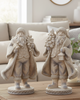 Two decorative Santa figures on a wooden coffee table in a living room setting.