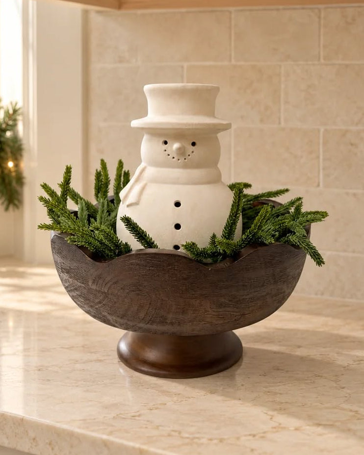Cooper dark wood pedestal bowl with scalloped edges, rich brown wood grain and raised base, styled with decorative moss balls