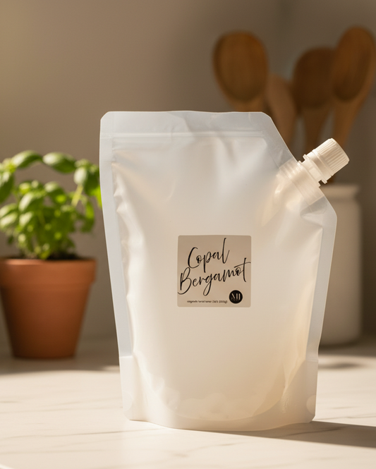 White product packaging with 'Loyal Bergamot' label on a wooden surface with a plant and bottles in the background.